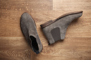 Pair of gray suede Chelsea boots on the floor. Top view
