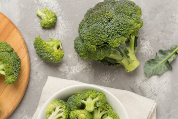 Fresh tasty broccoli on concrete background, top view