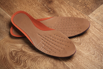Leather insoles on a wooden floor