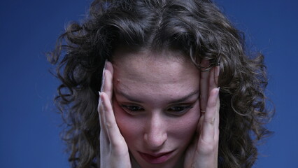 Frustrated young woman covering face with hands feeling regret and anxiety, close-up face of female...