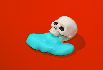 Creative layout with scary skull and slime on bright red background. Visual trend. Halloween concept. Minimalistic aesthetic still life with shadow. Fresh idea