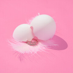 Creative layout with eggshell and golden crown on bright pink background. Visual summer trend....