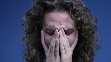 Frustrated young woman covering face with hands feeling regret and anxiety, close-up face of female...
