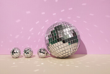 Creative minimal still life with mirrored disco balls on pastel background. Party concept. visual trend. Retro aesthetic