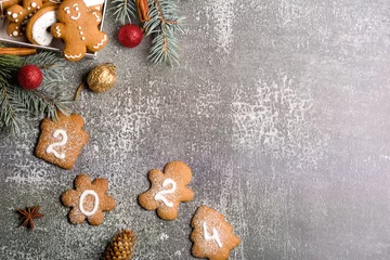 Tuinposter Gingerbread cookies of the form of numbers and 2024. Christmas composition with gingerbread on gray background. Copy space. Flat lay © shandor_gor