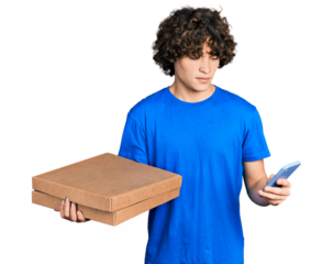 Caucasian teenager holding delivery package and showing smartphone screen clueless and confused expression. doubt concept.