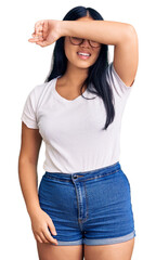 Fototapeta premium Young beautiful asian girl wearing casual clothes and glasses covering eyes with arm smiling cheerful and funny. blind concept.