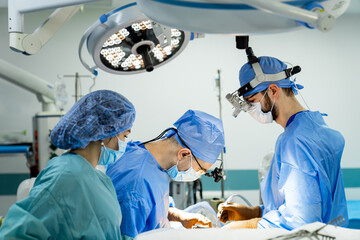 A group of doctors performing surgery in a hospital. Group of Doctors Performing Neurosurgery in a...