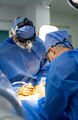 Two surgeons performing surgery in an operating room. Two Surgeons Performing Neurosurgery in a...