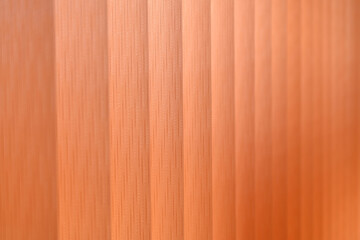 Naklejka premium Background of vertical orange blinds curtains. Pleated roller blinds. Orange striped background.