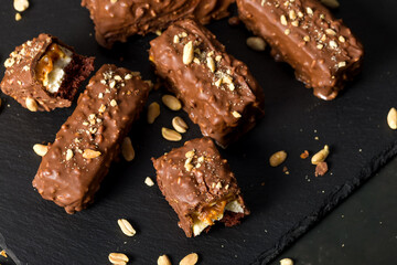 Chocolate sticks with peanuts on a dark background. Home cooking concept