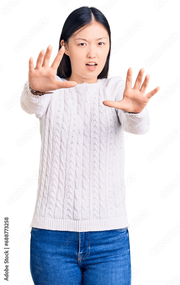 Sticker Young beautiful chinese woman wearing casual sweater afraid and terrified with fear expression stop gesture with hands, shouting in shock. panic concept.