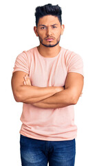 Handsome latin american young man wearing casual clothes skeptic and nervous, disapproving expression on face with crossed arms. negative person.