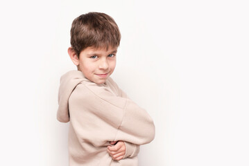 A young boy of 8 years old in hoodie is warmly dressed and smiling, portrait of a young cheerful...