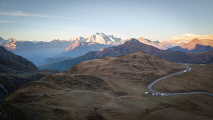 Aerial shot of mountain pass with curving road and beautiful mountains in backdrop, Dolomites, Italy