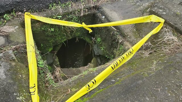 Open sewage with caution tape 