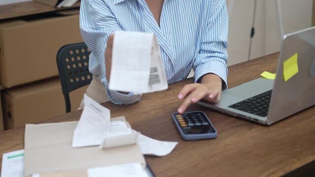 Woman with a bill, laptop, and a focus on online payments. Crunching numbers, assessing accounts, and loan details
