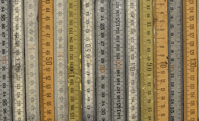 A variety of vintage wooden folding rulers arranged