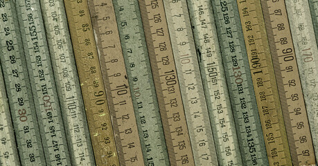 A variety of vintage wooden folding rulers arranged