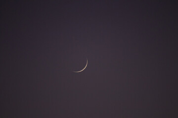Crescent moon at night with purple sky