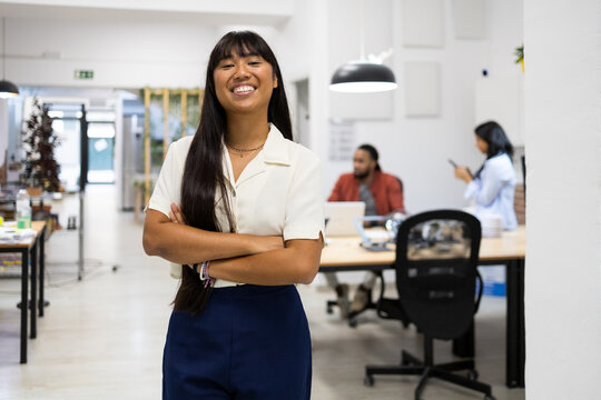 Smiling businesswoman with arms crossed in office