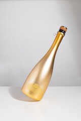 Gold champagne bottle on white table,