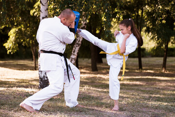 Portrait of girl doing martial arts at summer park outdoors