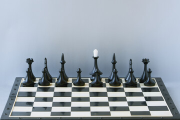 Black chess pieces stand on the board without a king. Absence of a leader, position uncertainty, leaderless