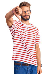 Handsome blond man with beard wearing casual clothes and glasses looking unhappy and angry showing rejection and negative with thumbs down gesture. bad expression.