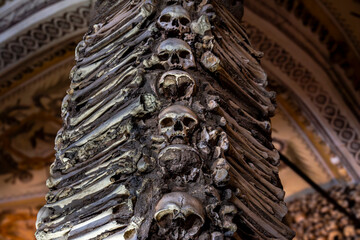 Column of human skulls with bones on the sides creating a macabre design of The Chapel of Bones...
