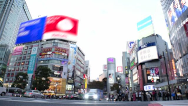 SHIBUYA, TOKYO, JAPAN - NOV 2023 : Shibuya Crossing in sunset. Crowd of people, car, taxi and bike at the street. Time lapse shot, dusk to night. Japanese urban city life and transportation concept.
