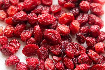 Dried natural cranberries in a wooden spoon close-up.