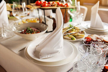 Festive serving, setting table. Plate decorated white napkin, cutlery, empty crystal wine glasses...
