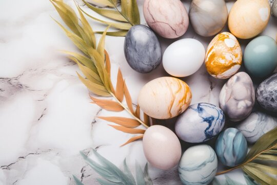 Natural colorant painted eggs with marble effect on table with tropical leaves, happy Easter celebration concept.