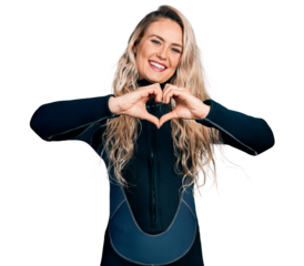 Young blonde woman wearing diver neoprene uniform smiling in love doing heart symbol shape with hands. romantic concept.