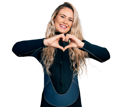 Young blonde woman wearing diver neoprene uniform smiling in love doing heart symbol shape with hands. romantic concept.