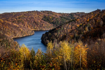 Fototapeta na wymiar Landscape with Bystrzyckie Lake and autumnal forest in the Owl Mountains in Poland. 