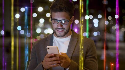 Handsome Breaded Businessman texting on Smartphone. Beams of Light, Big Data, Futuristic Technology Information as Columns of Light. City at Night.
 - Powered by Adobe
