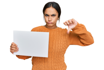 Young brunette woman holding blank empty banner with angry face, negative sign showing dislike with thumbs down, rejection concept