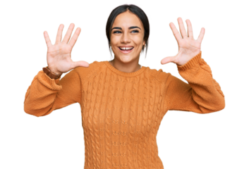 Young brunette woman wearing casual winter sweater showing and pointing up with fingers number ten while smiling confident and happy.