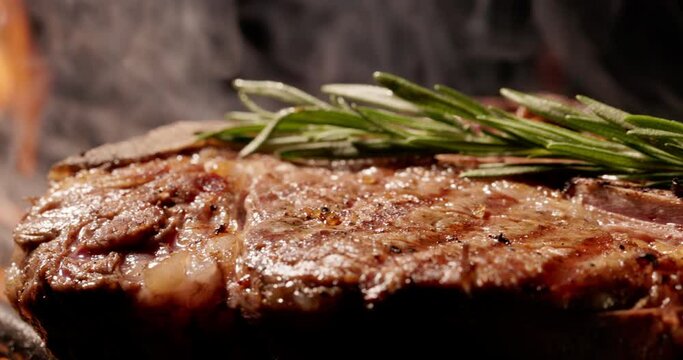 Close-up, symphony of flavors by grilling juicy piece of steak with rosemary over hot coals. Smoky aroma and delicious char make every dish sensation to savor. Cinematic advertising, copy space