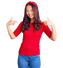 Obraz na płótnie Canvas Young beautiful chinese girl wearing casual clothes and diadem looking confident with smile on face, pointing oneself with fingers proud and happy.