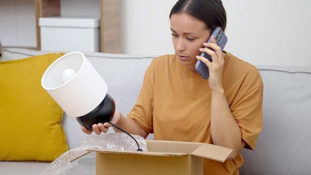 Package Mix-Up: At home, a dismayed lady with an open box, grappling with a shipping error, engages in return talks with customer support. 