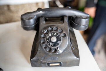 Old dial up analog phone in antique shop. Home and business phone in black.