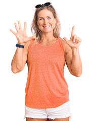 Fototapeta na wymiar Middle age fit blonde woman wearing casual summer clothes and sunglasses showing and pointing up with fingers number seven while smiling confident and happy.