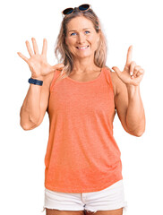 Middle age fit blonde woman wearing casual summer clothes and sunglasses showing and pointing up with fingers number seven while smiling confident and happy.