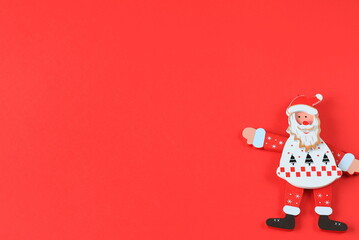 Toy Cheerful Santa Claus shows on red background. Smiling cartoon old man in suit, saint nicholas, New Year, Christmas greeting card. Holiday Christmas