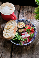 bowl with fried eggplants, radishes, tomatoes, cucumber and cilantro.