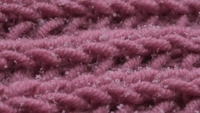 Delicate white snowflakes gently descend onto woolen knitted background, captured in mesmerizing macro detail, winter romance and natural beauty outdoors, meteorological phenomena and seasonal changes