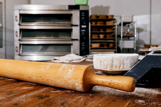 Rolling pin on wooden table in bakery